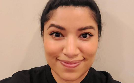 Daisy Galan, wearing a black shirt with a neutral background