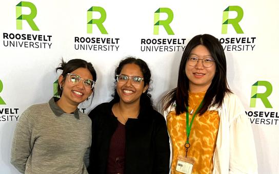 Three international students in front of a Roosevelt-branded screen