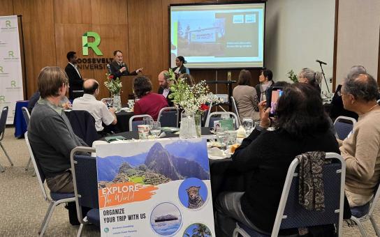 event participants at tables listen to professor Brian Margulis present
