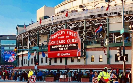 Exterior of Chicago's Wrigley Field home to the Chicago Cubs before a baseball game with fans gathered around the building and streets.