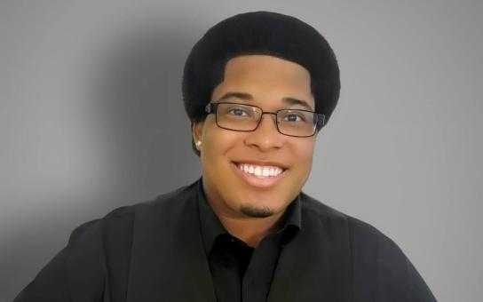 Portrait of Professional Diploma in Opera student, Benjamin Burney smiling and wearing a black collared shirt.
