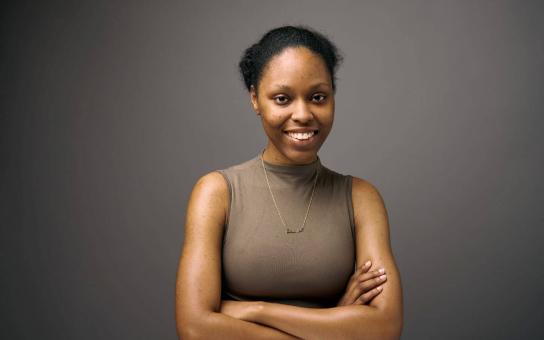 Danijah Davis, Heller College of Business Student in the Organizational Leadership program, standing with arms folded across chest.