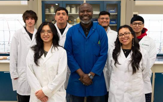 Dr. Oluseye Onajole standing with students in a lab