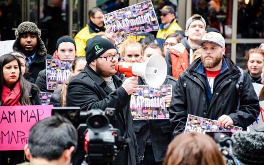 Guy speaking through a megaphone in the middle of rally