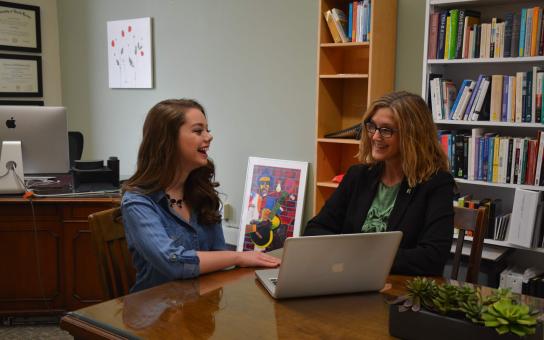 Smiling female student with woman counselor