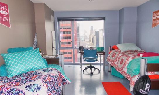 View of a double-occupancy dorm room with two beds and two desks.